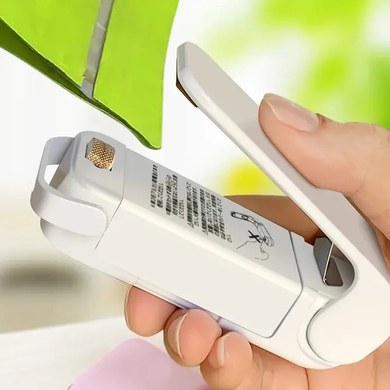 Close-up of a Mini Heat Bag Sealing Machine Package Sealer in use for sealing food bags.