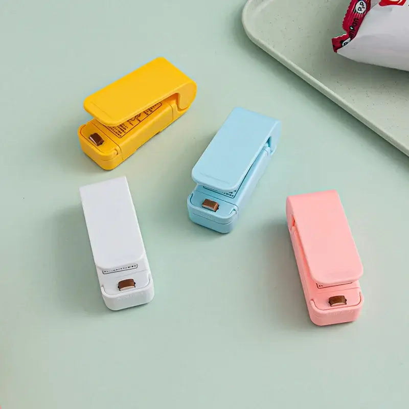 Mini Heat Bag Sealing Machine in four colors: yellow, blue, white, and pink for easy food bag sealing.